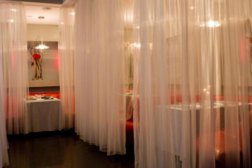 a room with white curtains and a table at Hotel Complex Zelenyi Gai in Kopachuvka