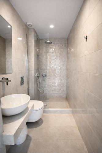 a bathroom with a toilet and a sink and a shower at Babis Hotel in Karterados