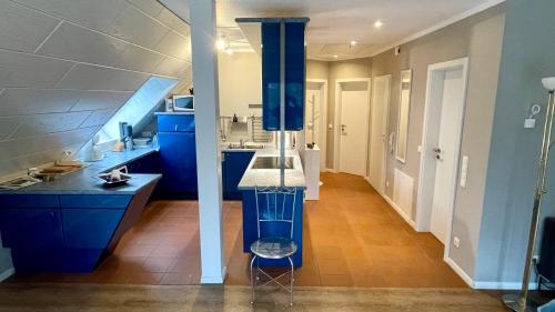 a large kitchen with blue cabinets and a sink at Fewo Ostseetraum Laboe in Laboe