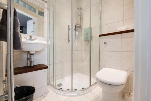 a bathroom with a shower and a toilet and a sink at Ferryman Studio Apartments in Portsmouth