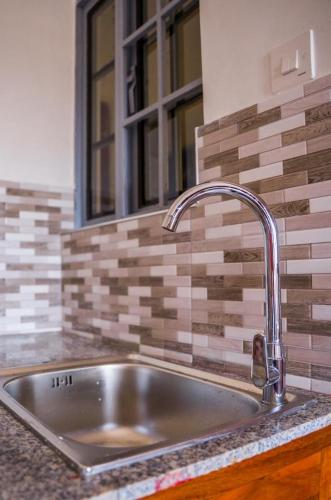 a stainless steel sink in a kitchen with a window at Osim Bnb in Arusha