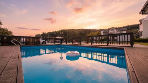 a swimming pool on a deck with a house at Daebudo Sketch Pension in Ansan