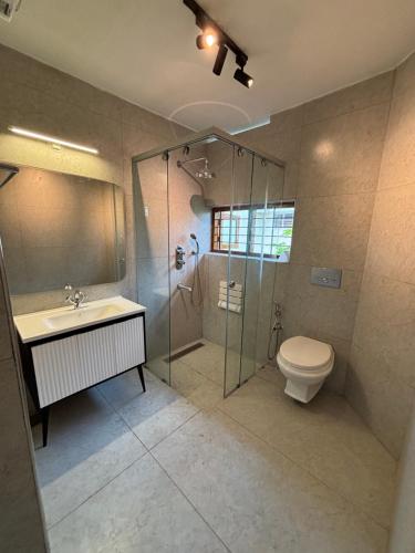 a bathroom with a shower and a toilet and a sink at Ushas Homestay in Trivandrum
