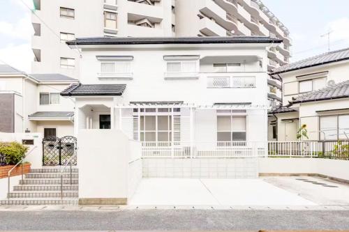 a white apartment building with stairs in front of it at Itoshima Private Villa 4LDK 4-Bedroom in Itoshima