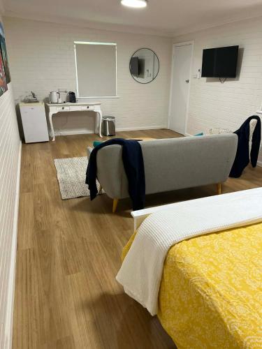 a room with two beds and a table and a kitchen at Beach House Studio in Busselton