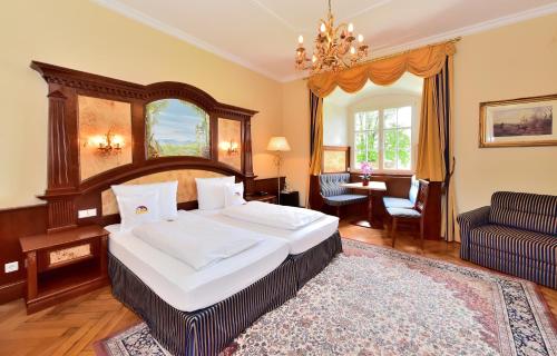 ヴァッサーブルクにあるシュロス ホテル ヴァッサーブルクのベッドルーム(大型ベッド1台付)、リビングルームが備わります。