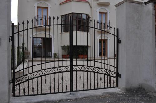 a black gate in front of a white house at Ibasilischi in Irsina