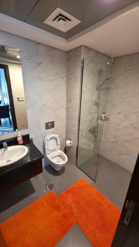 a bathroom with a shower and a toilet and a sink at Elegant and comfortably furnished 2BRH apartment in a quiet area! in Dubai