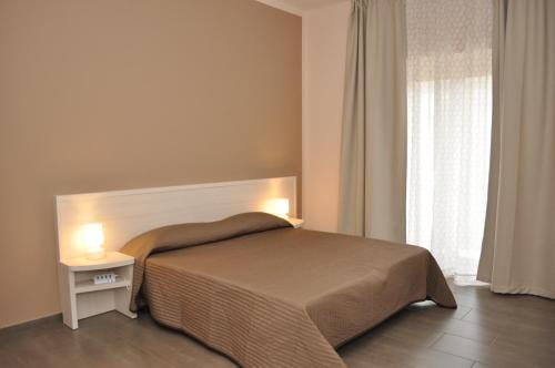 a bedroom with a bed with two lights on it at Ibasilischi in Irsina