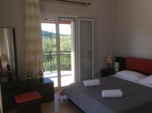 a bedroom with a bed and a sliding glass door at Villa Natalia in Kouramádes