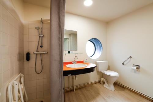 a bathroom with a sink and a toilet at Logis Hôtel Le Keréden in Locarn