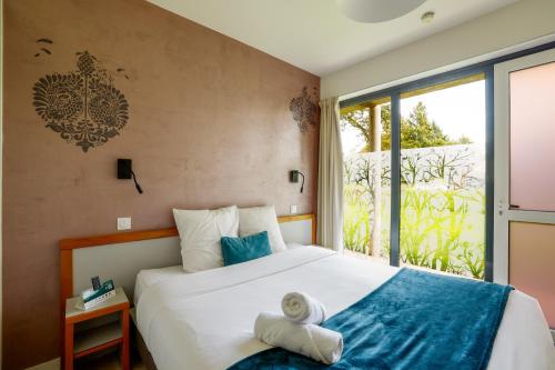 a bedroom with a bed with towels on it at Logis Hôtel Le Keréden in Locarn