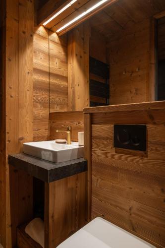 a bathroom with a sink in a wooden room at Sorelle Chalet, spa, indoor pool, lake view in Gérardmer