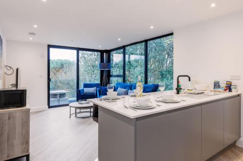 a kitchen with a large white island with blue chairs at Aurora South - Short Walk to Ashley Cross in Poole