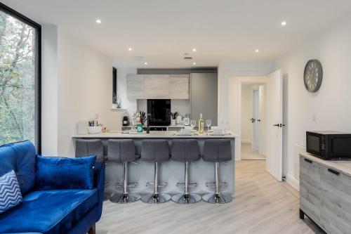 a kitchen and living room with a blue couch at Aurora South - Short Walk to Ashley Cross in Poole