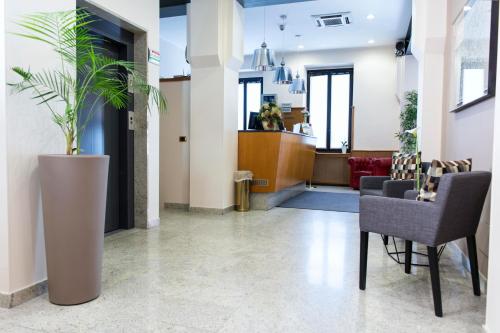 a lobby with a potted plant and chairs at Hotel Florence Milano in Milan