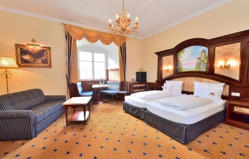 una camera d'albergo con due letti e un divano di Schloss Hotel Wasserburg a Wasserburg