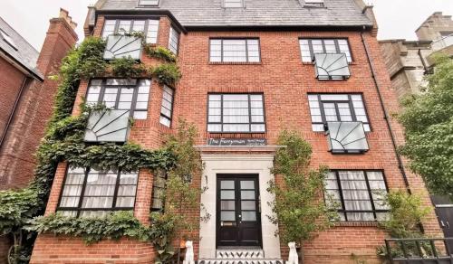 a red brick building with windows and ivy at Ferryman Studio Apartments in Portsmouth