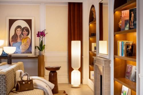 a living room with a picture of two women at Almarine Eiffel Hotel & Spa by Malone in Paris