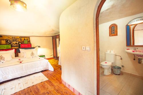 a large bedroom with a bed and a toilet at Riad Lamane in Zagora