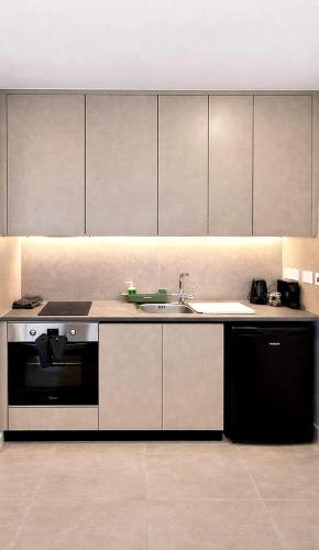 a kitchen with a sink and a stove at White Arches Studio Suite by TrulyCyprus in Limassol