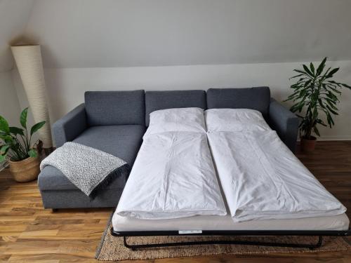 a couch with a white blanket on it in a living room at Wohlfühlende Wohnung nähe Dortmund in Witten