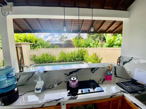 a kitchen with a counter top with a window at Ubud jungle House behind bintang supermarket ubud in Ubud