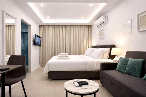a hotel room with a bed and a couch at White Arches Studio Suite by TrulyCyprus in Limassol
