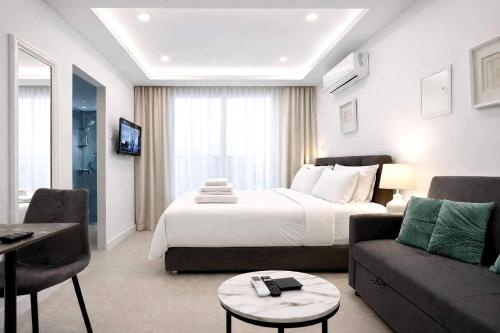 a hotel room with a bed and a living room at White Arches Studio Suite by TrulyCyprus in Limassol
