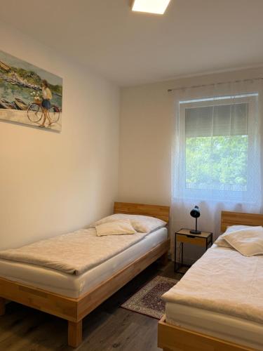 a bedroom with two beds and a window with a bike on the wall at Sorinas Home - Comfortable Apartment near Graz - Free Parking in Wagersbach
