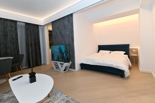 a bedroom with a bed and a flat screen tv at Cortina Nord Panoramic Studio in Voluntari