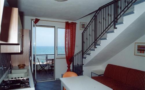 a living room with stairs and a view of the ocean at Etruriamare in San Vincenzo