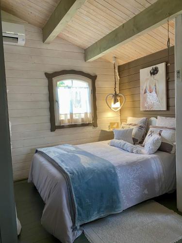 a bedroom with a large bed and a window at Chalet de Charme in Aniane