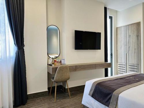 a bedroom with a bed and a mirror and a tv at LION 5 HOTEL in Can Tho