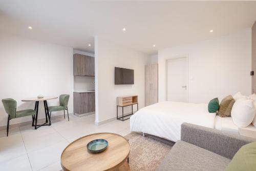 un soggiorno con un letto, un divano e un tavolo di The Bantree a Accra