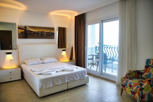 a bedroom with a bed and a balcony at Hotel Gumbet in Bodrum City