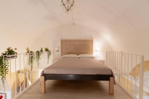 a bed in a white room with a staircase at SASSO BIANCO in Matera
