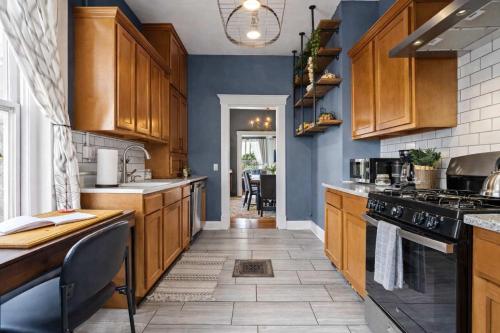 a kitchen with blue walls and wooden cabinets at Walkable Historic District Riverview Escape in Jeffersonville