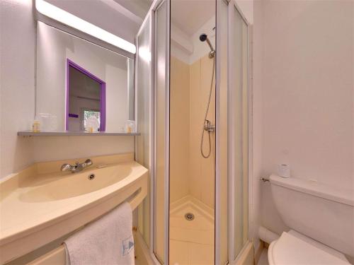 La salle de bains blanche est pourvue d'un lavabo et d'une douche. dans l'établissement The Originals Access, Hôtel Béziers Est (P'tit Dej-Hotel), à Villeneuve-lès-Béziers