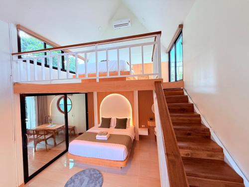 a bedroom in a house with a bed and a staircase at Lanta Forest Resort & Villas in Ko Lanta Yai
