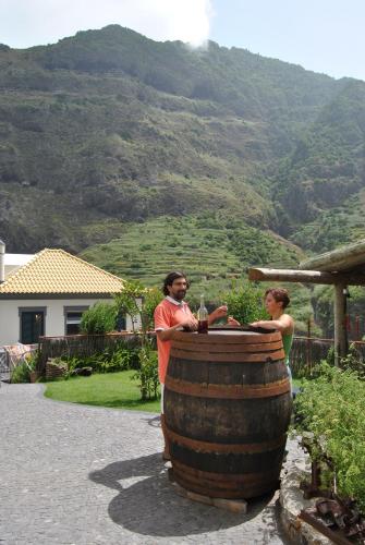 a man and a woman standing next to a barrel at A Casa Estrelícia-Dourada Garcês in São Vicente