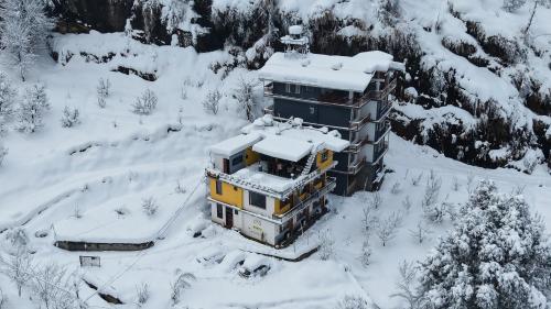 Luftaufnahme eines schneebedeckten Gebäudes in der Unterkunft Firefly Hostel in Manali
