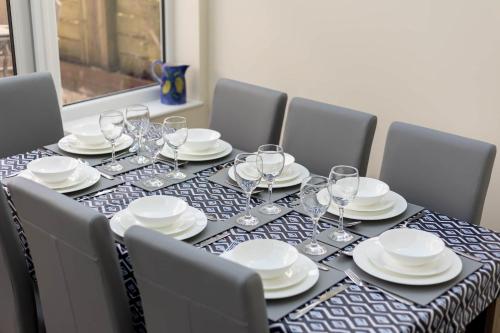 a table with plates and wine glasses on it at Avalon - Walking Distance to Poole Quay and Town in Poole