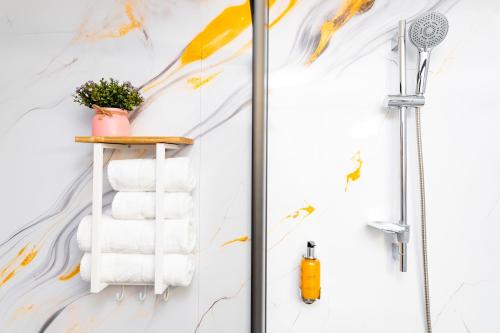 a bathroom with a shower with towels on a shelf at Hotel Ciao in Târgu-Mureş