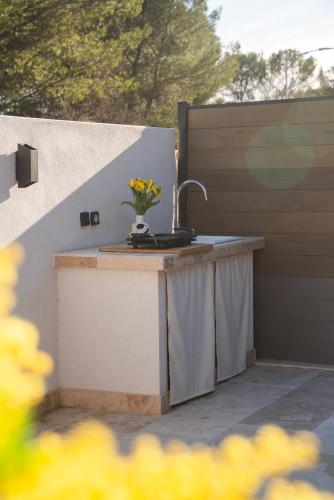 a outdoor kitchen with a sink on a patio at Le Cocon du Golf in Nîmes