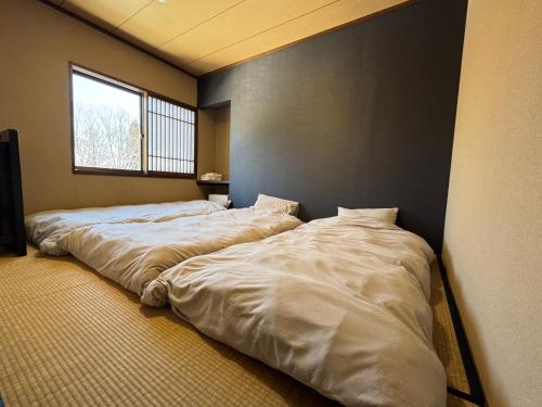 two large beds in a room with a window at Fuji-Kurohime- in Shinano