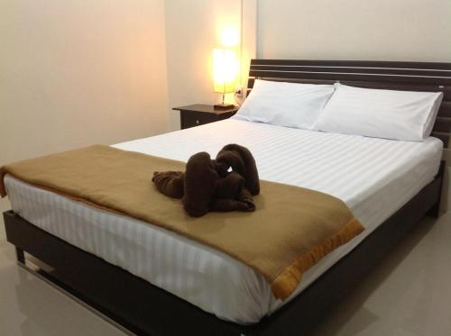 a stuffed teddy bear sitting on a bed at Baan Chan Suan in Nong Nam Daeng