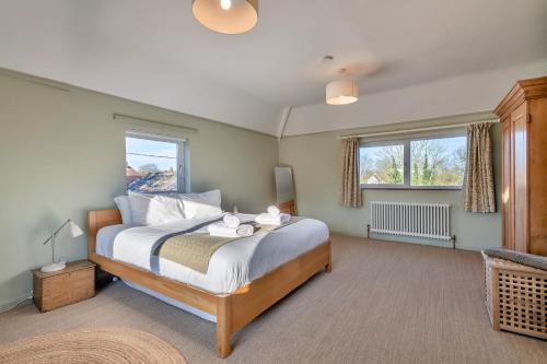 a bedroom with a large bed and two windows at Finest Retreats - The Old Windmill in Hindolveston