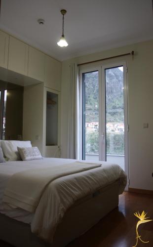 a bedroom with a large bed and a large window at A Casa Estrelícia-Dourada Garcês in São Vicente