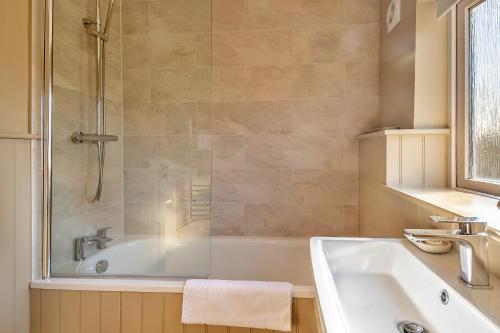 a bathroom with a tub and a sink and a shower at Finest Retreats - The Old Windmill in Hindolveston